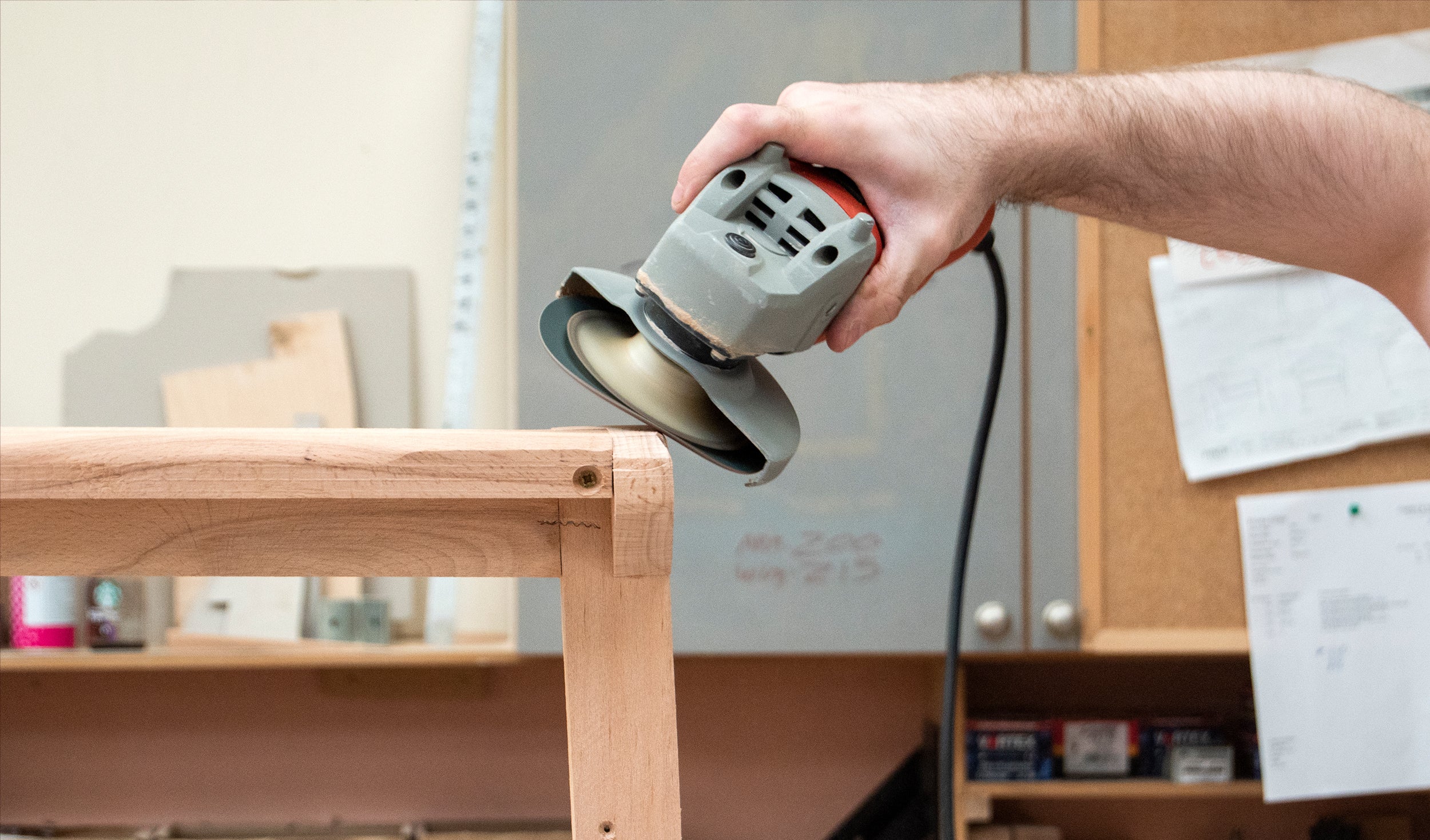 Solid wooden furniture frame being sanded.
