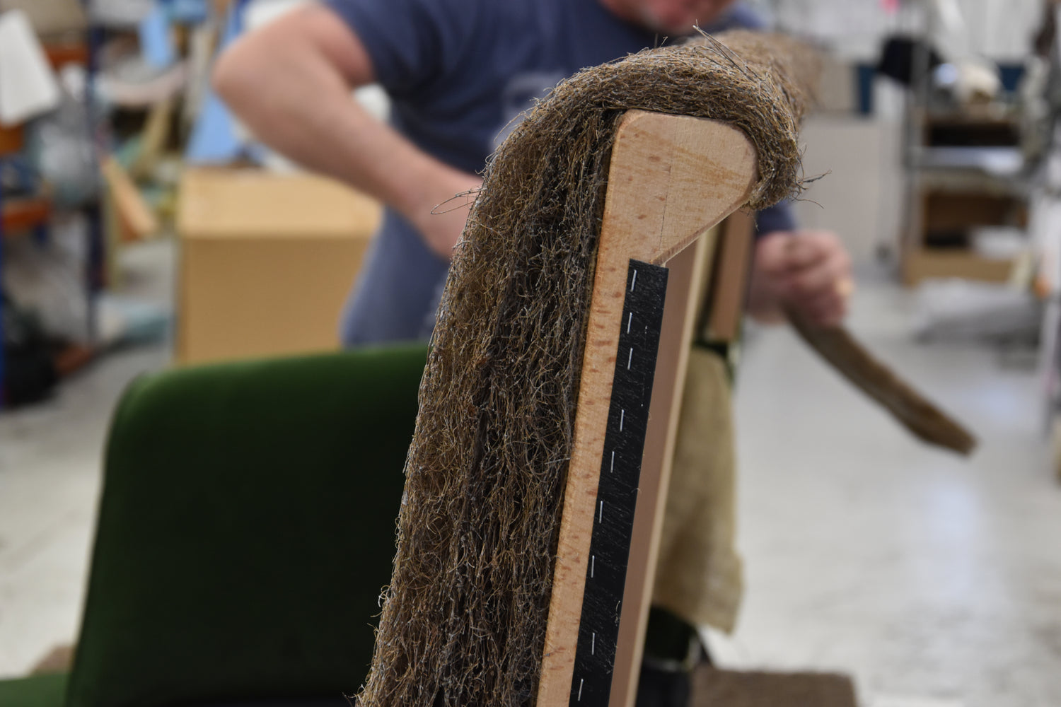 Latex & coconut fibres being fixed to a wooden sofa frame.